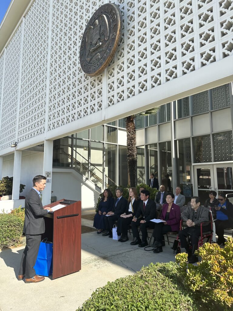 A picture from the welcome ceremony in front of City Hall. Councilmember Jeff Maloney is speaking to the attendees.