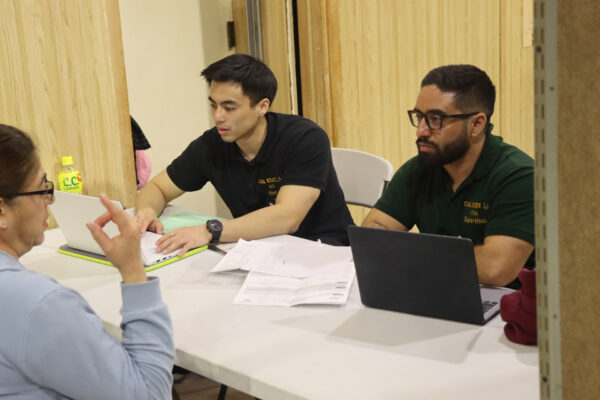 Members of the Voluntary Income Tax Assistance (VITA) program at Cal State LA confer with a client during the 2024 tax season. (Credit: Cal State LA)